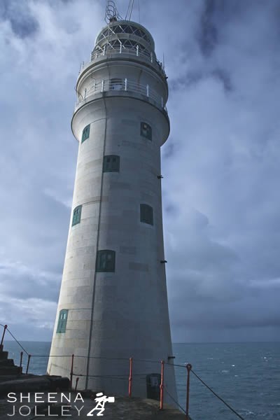 Looking up at the Fastnet Rock from the helipad. Beyond is a stormy sky and an eerie light